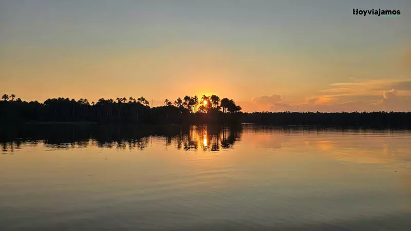 Reflejos de la luz del atardecer sobre el Lago Sandoval y la vegetación de la Reserva Nacional Tambopata