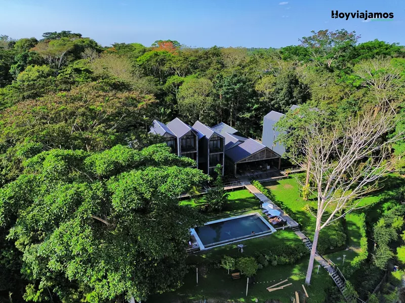Vista aérea del hotel Enai junto al río Madre de Dios, rodeado de vegetación tropical en Puerto Maldonado